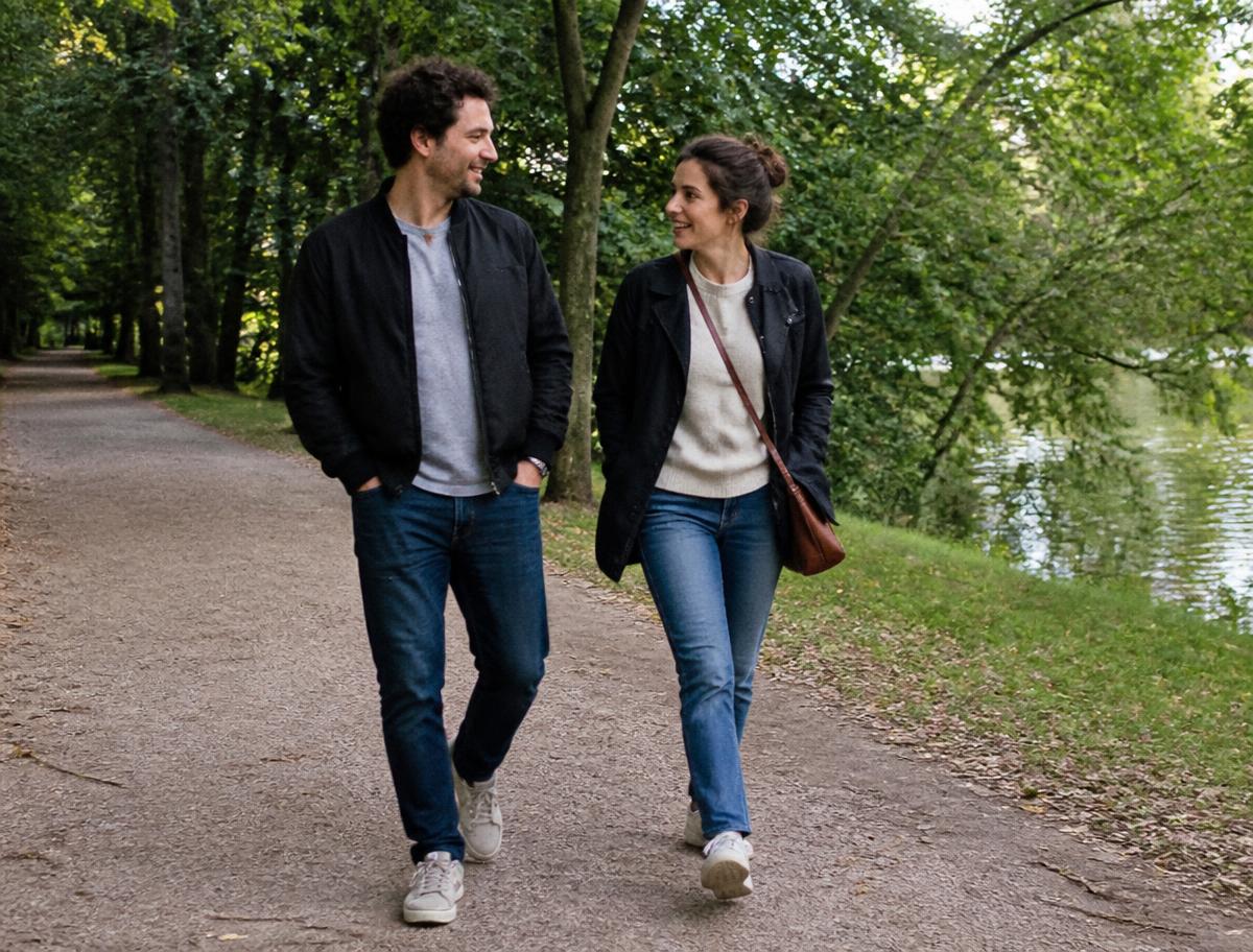 Man och kvinna i 30-årsåldern promenerar och pratar på en stig